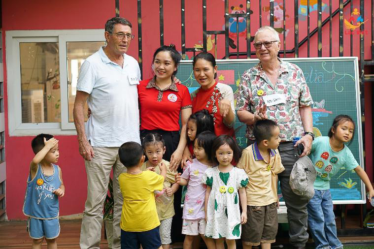 Adults: (L-R) – Brian, a Teacher, Ms Phuong (the owner) and Dr Denis – posing with some of the kindergarten children after our English session on Australian animals