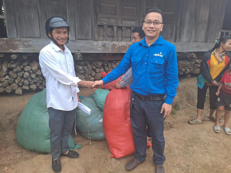Mr Ha (in MIVAC shirt) arriving with bags of clothes, and being thanked by the village chief